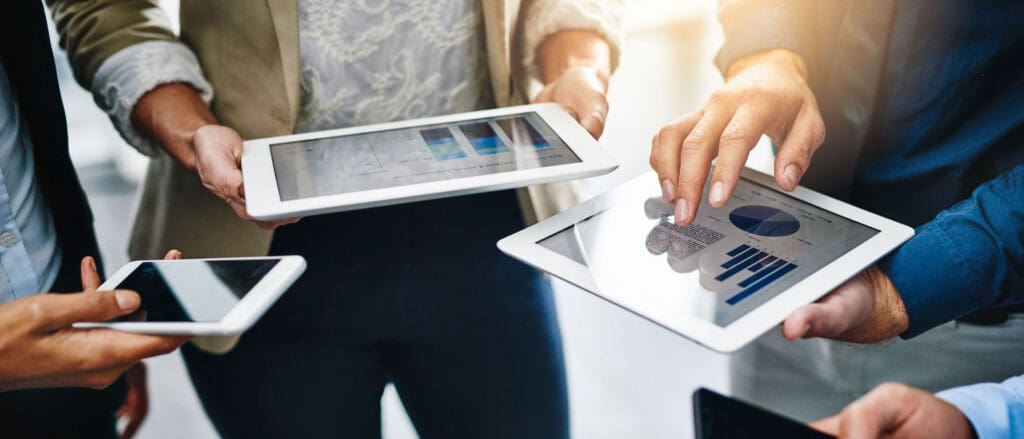 Three people looking at tech trends in financial services graphs