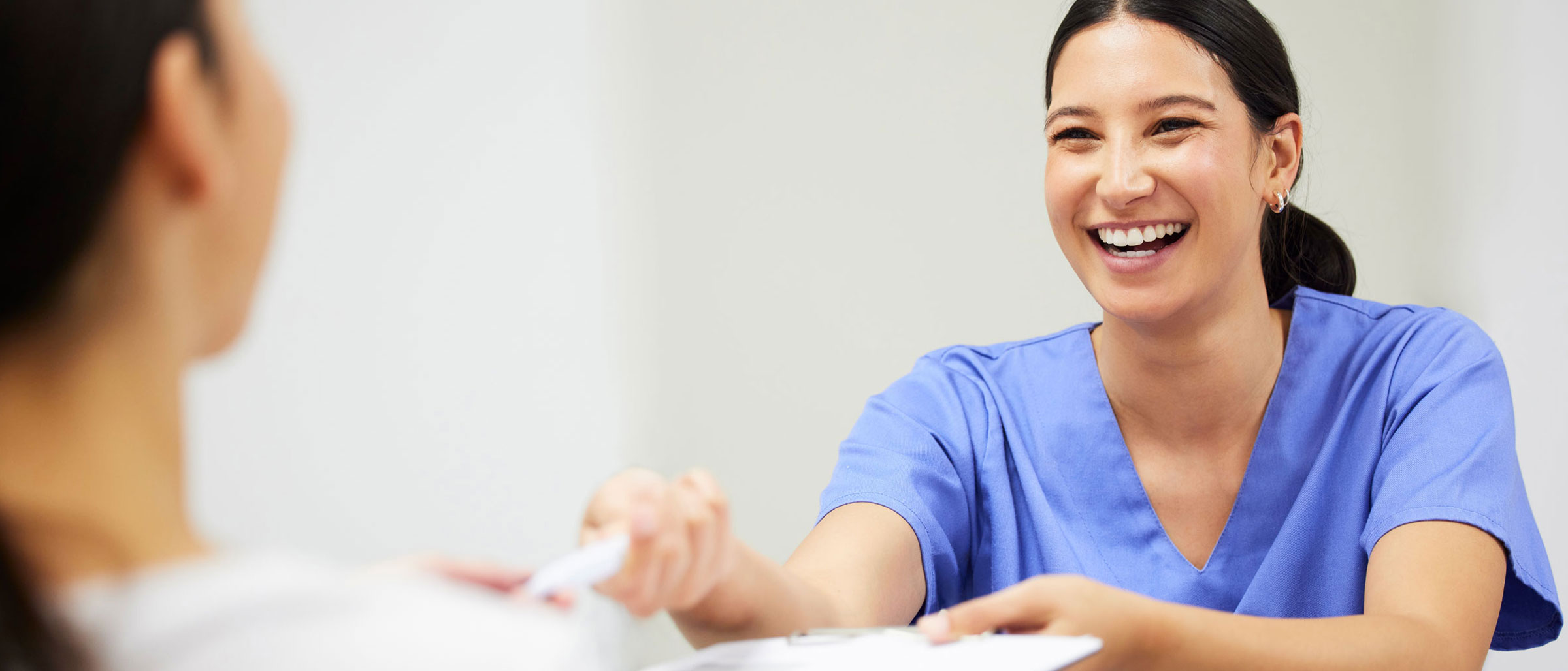 Female Nurse shaking woman's hand