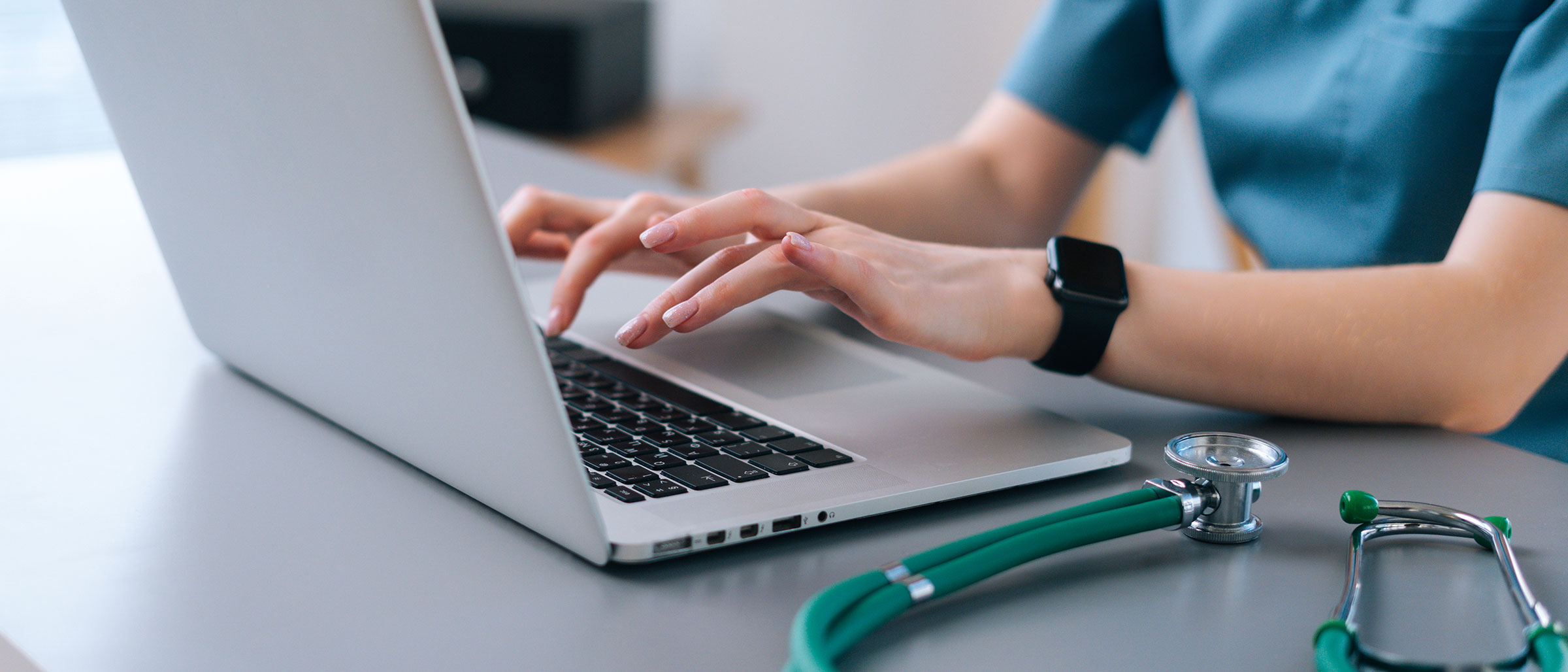 Nurse typing on laptop