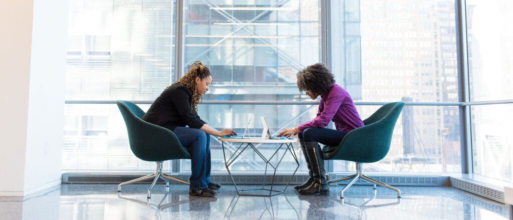 Two women seated in chairs facing each other in conversation