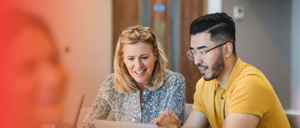 Man and Woman smiling, looking at paper