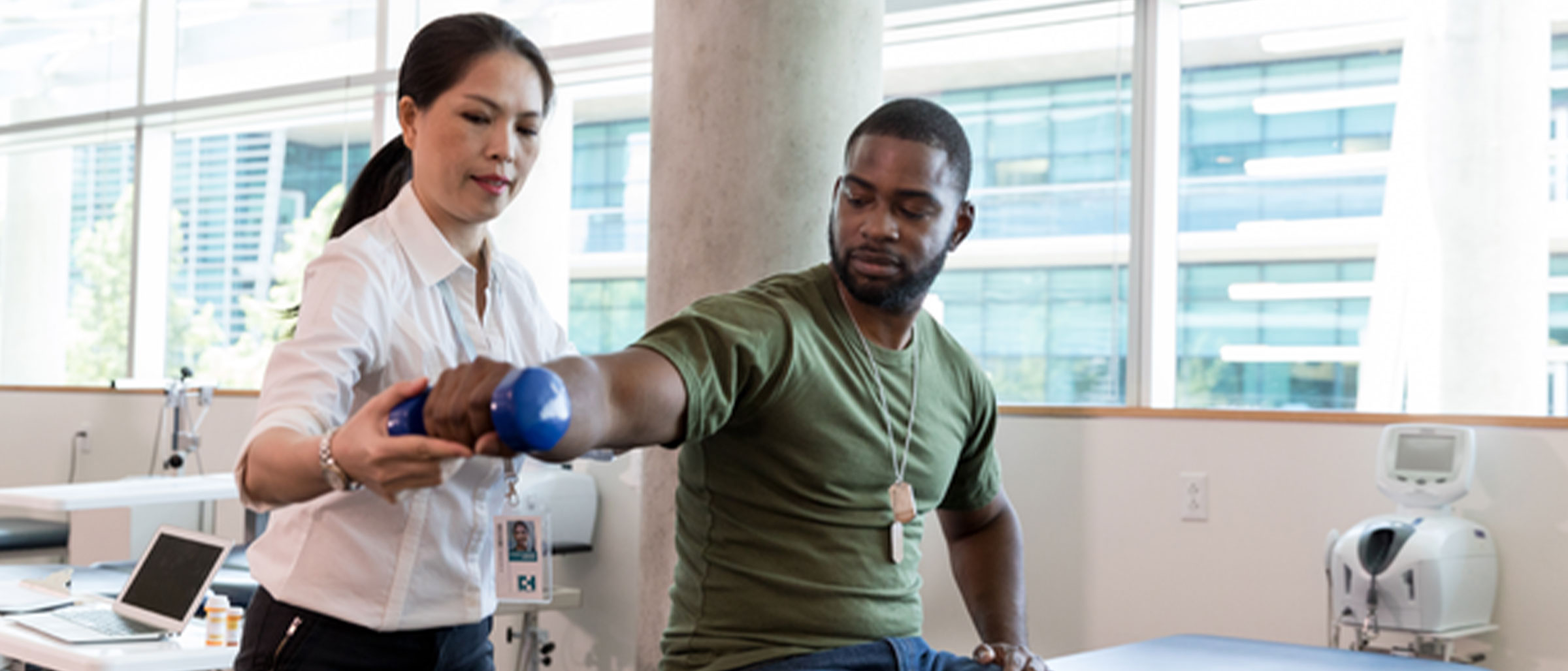 Physical therapist helping man lift weight