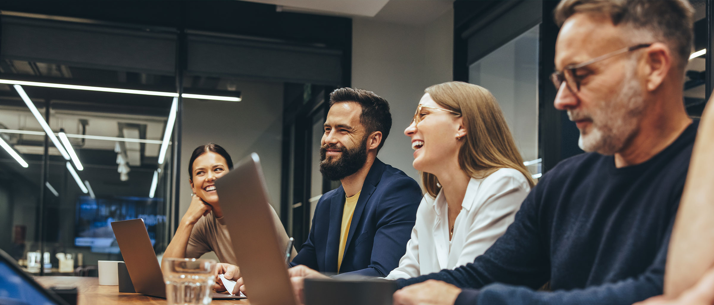 Group of co-workers laughing in board room