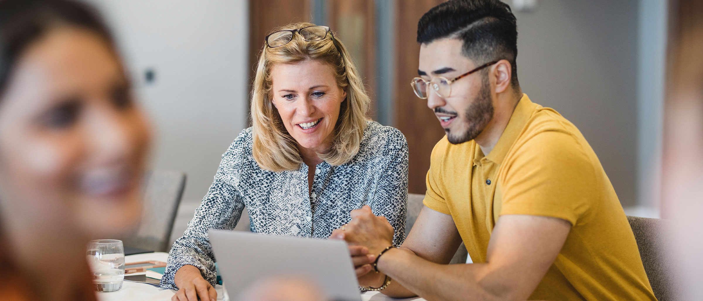 Woman and man smiling looking at tablet