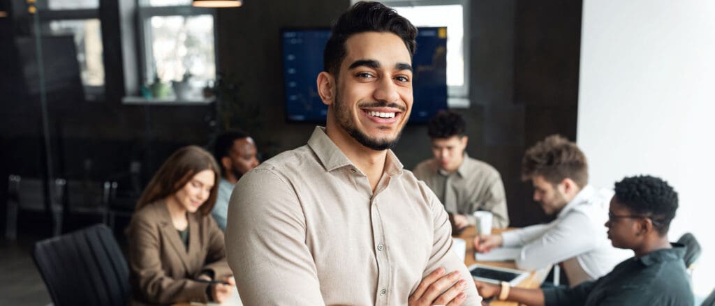 Man smiling in conference room full of peers