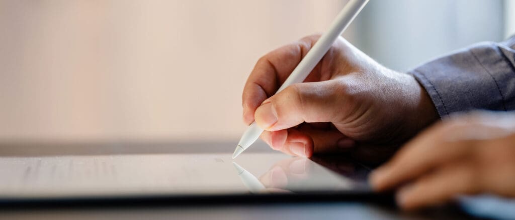 Person writing on a tablet with a stylus