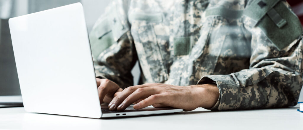 Person in camo uniform on laptop