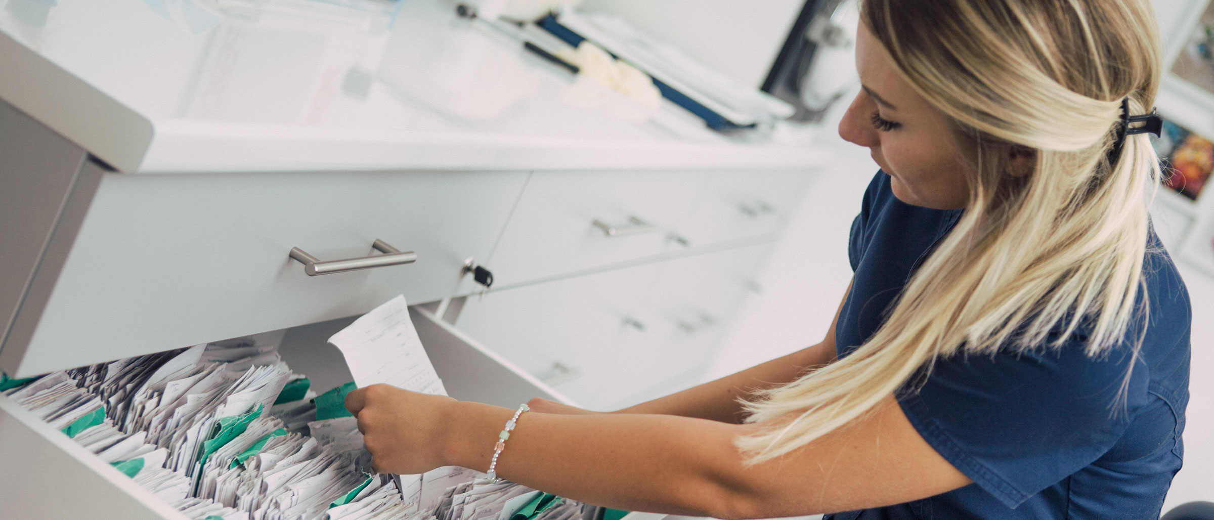 Healthcare professional looking through filing cabinet