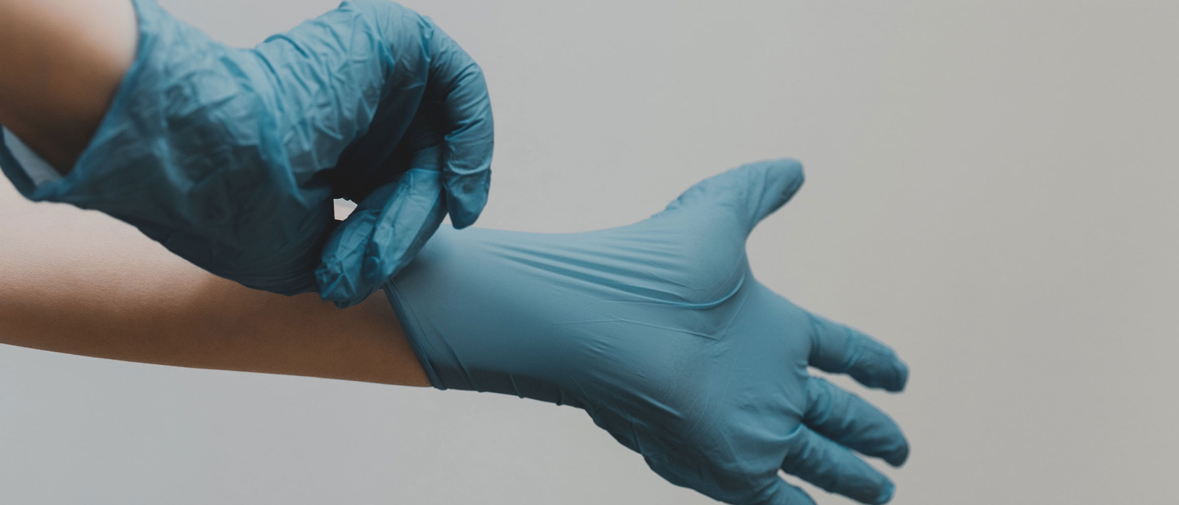 Healthcare worker putting on medical gloves
