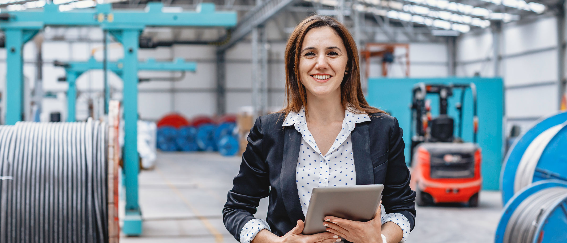 Woman smiling holding tablet in warehouse