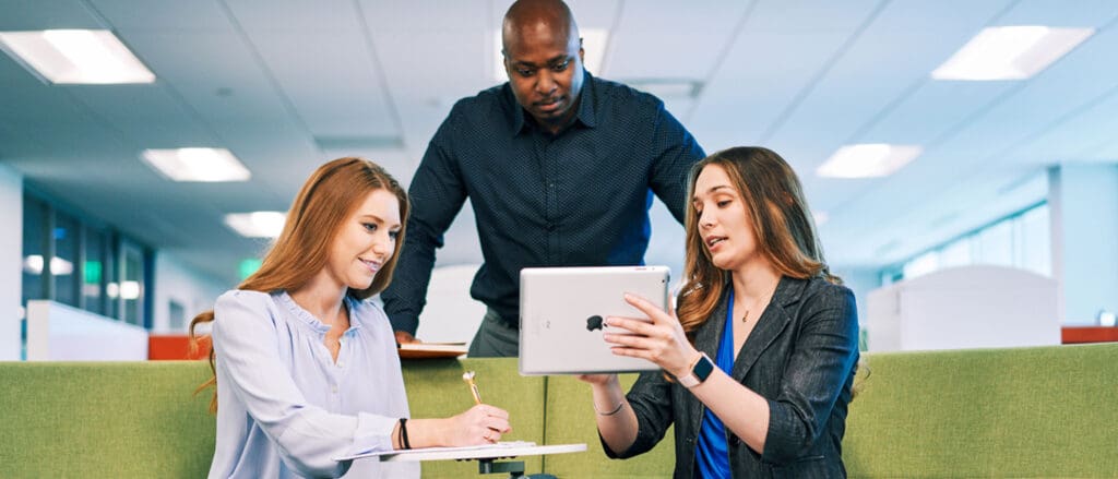 Woman showing co workers tablet screen