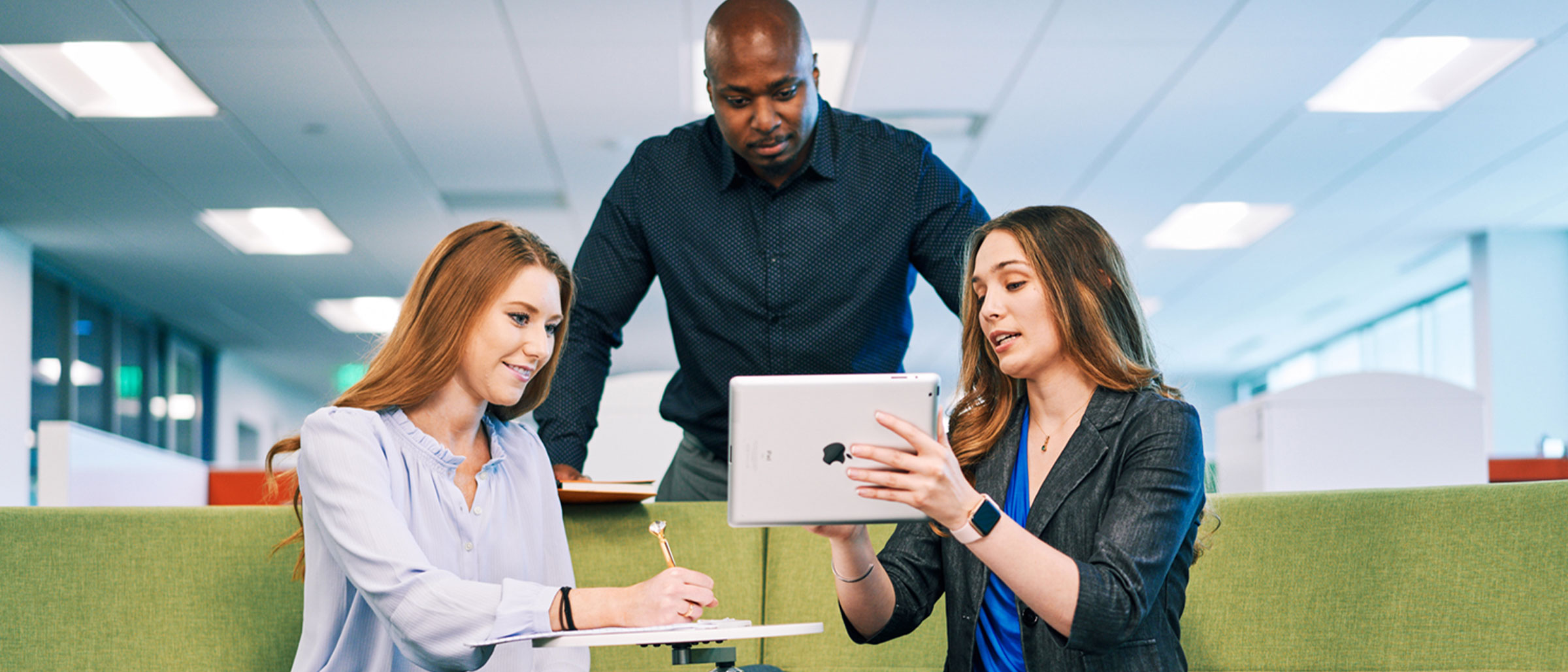 Woman showing co workers tablet screen