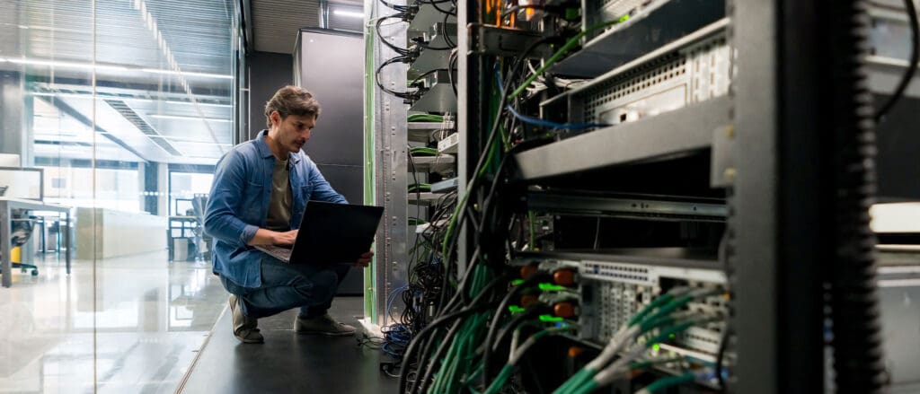 Man in server room on laptop