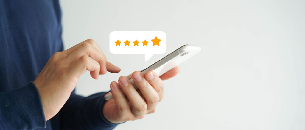 Person holding phone giving 5 star review