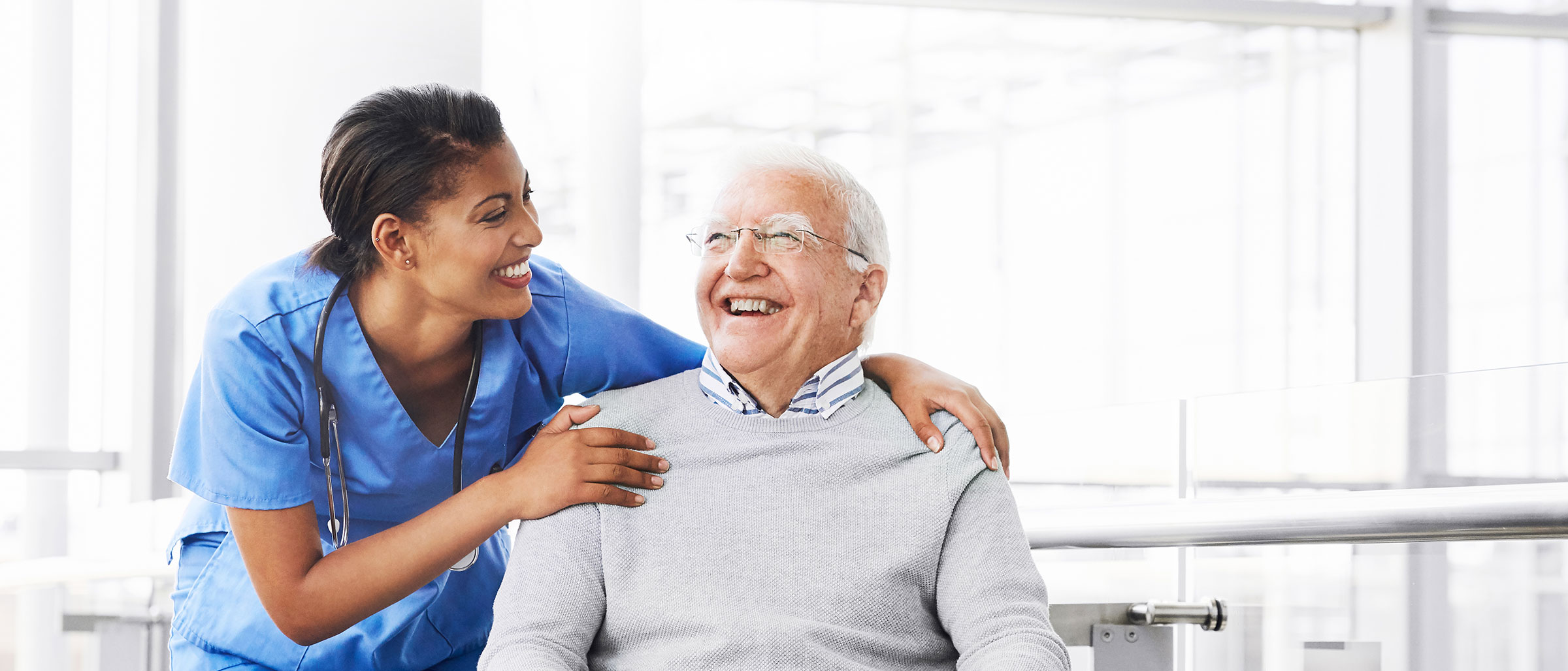 Female Healthcare Worker Hugging Old Man