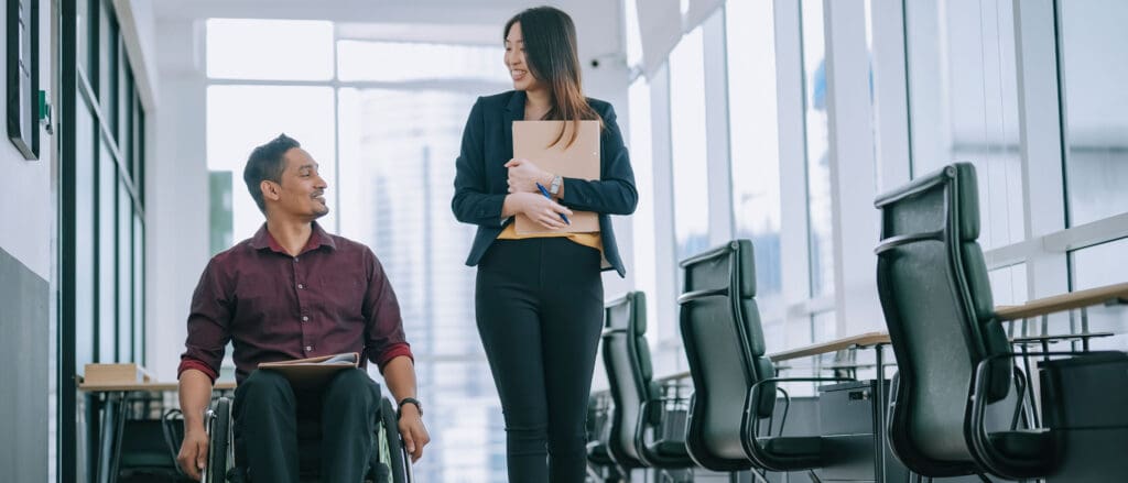 Woman walking next to man in wheelchair