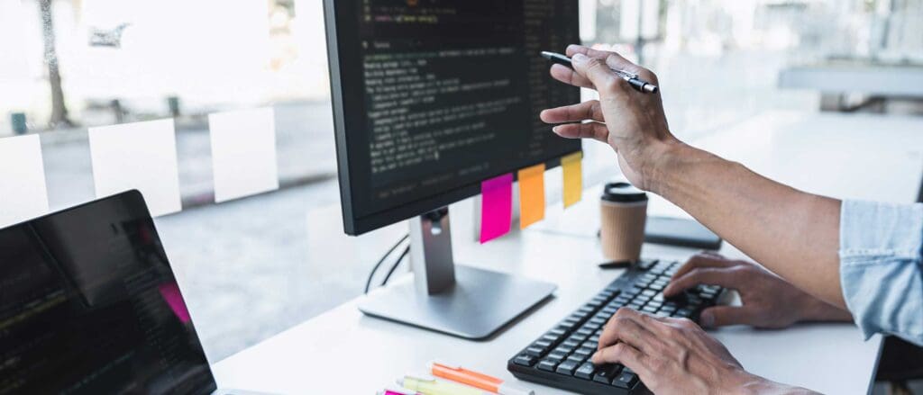 Person pointing at computer screen with pen