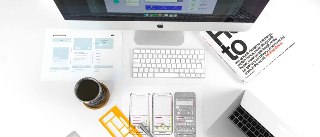 A desk with a computer, a phone and a cup of coffee