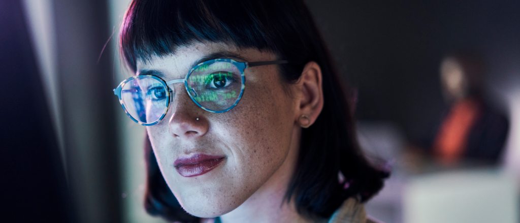 Woman wearing glasses staring at computer screen