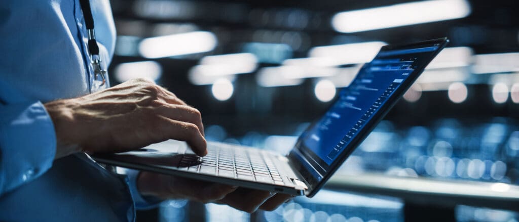 Person typing on laptop with one hand