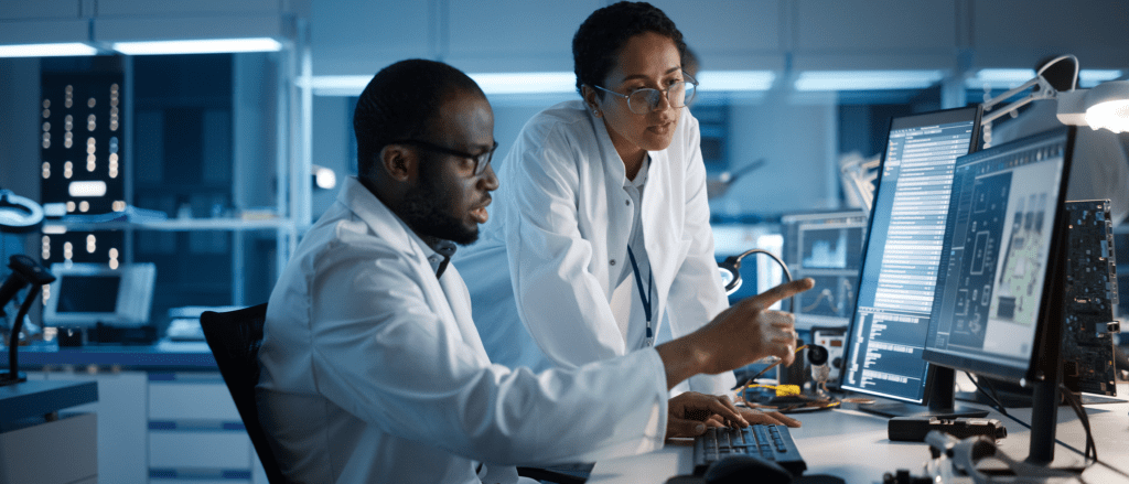 Man and Woman looking at computer screens with Semiconductor information