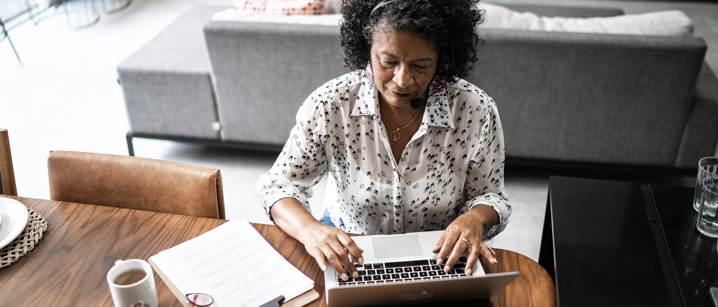 Woman typing on laptop at kitchen table