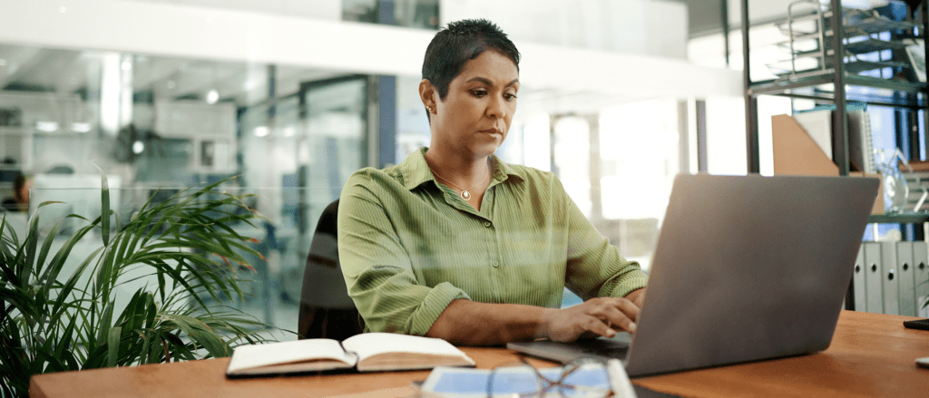 Medical Coder working on laptop in office space