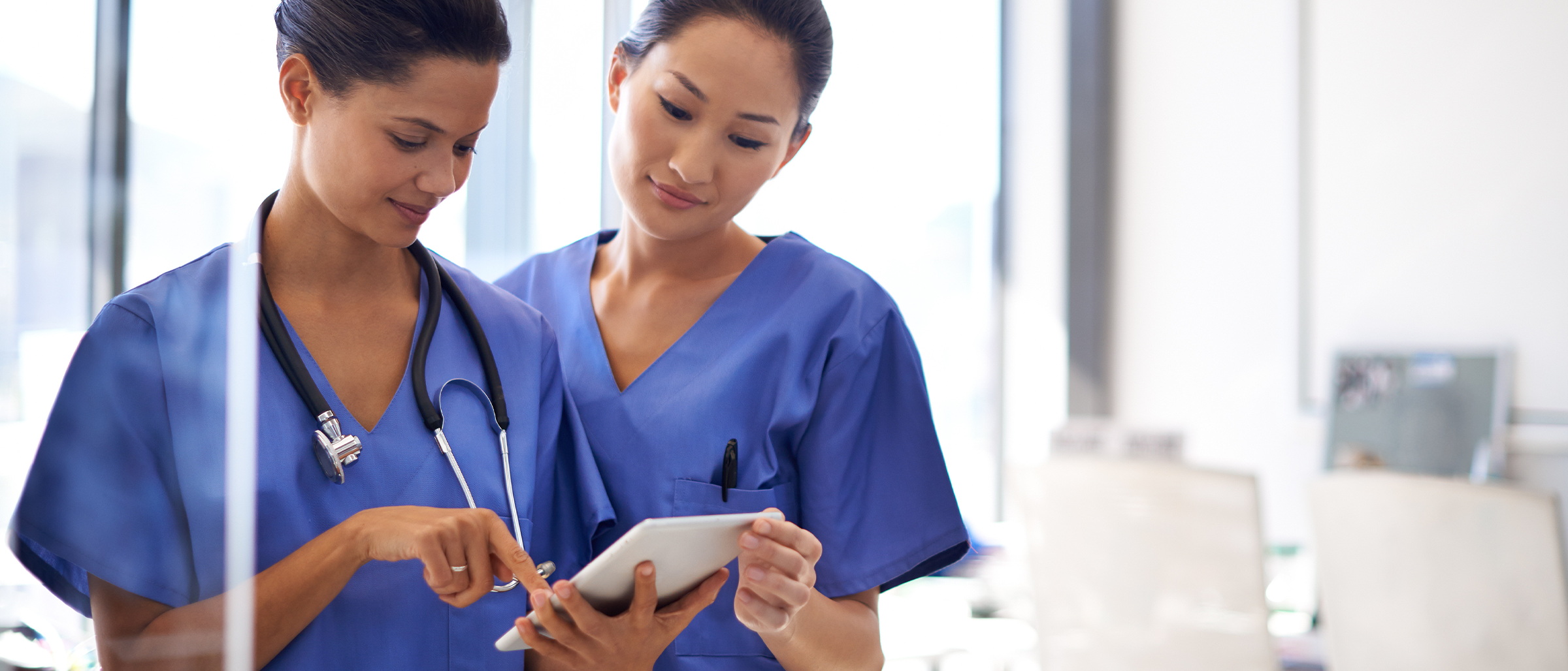 Two female medical professionals looking at medical device