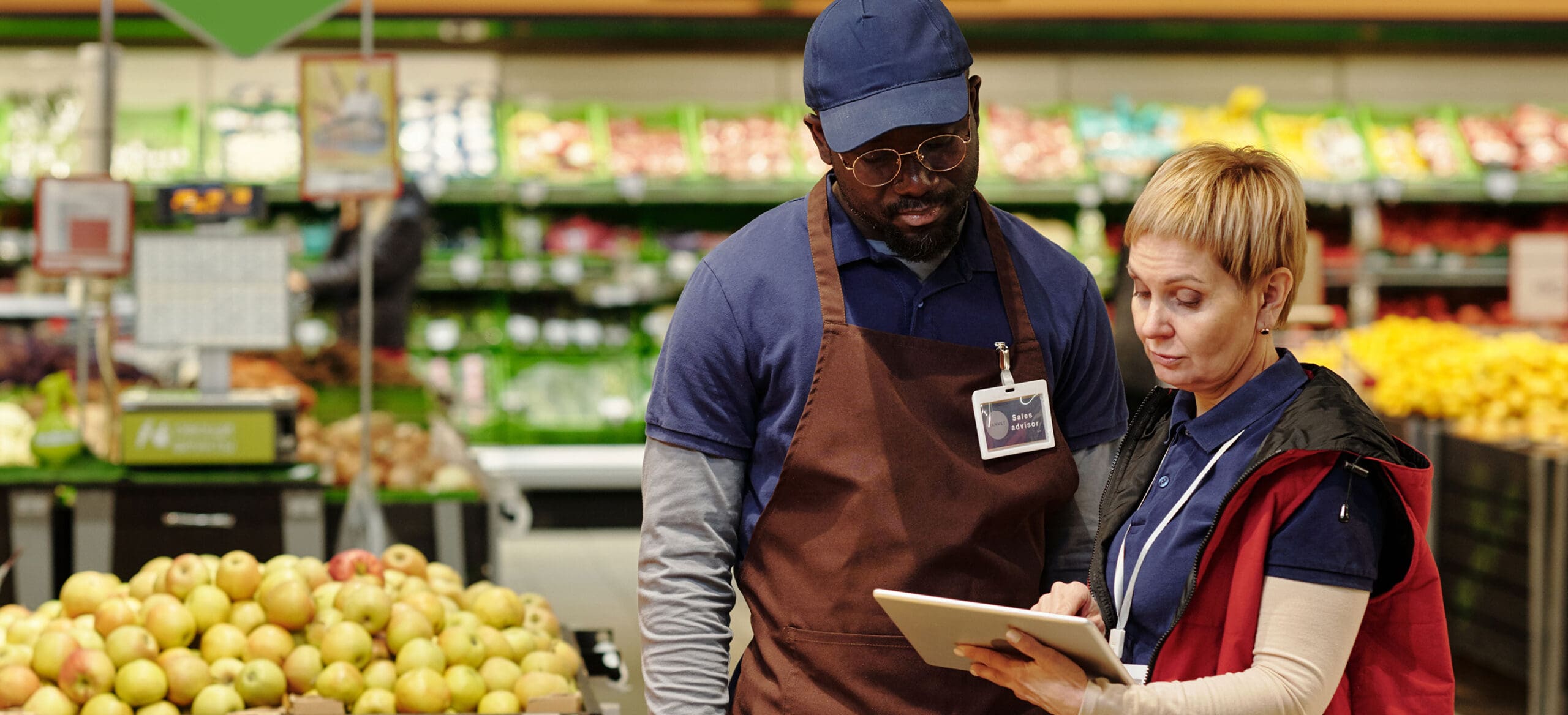 Man and woman looking at tablet in grocery store