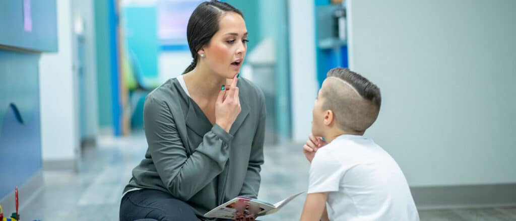 Speech pathologist helping young child
