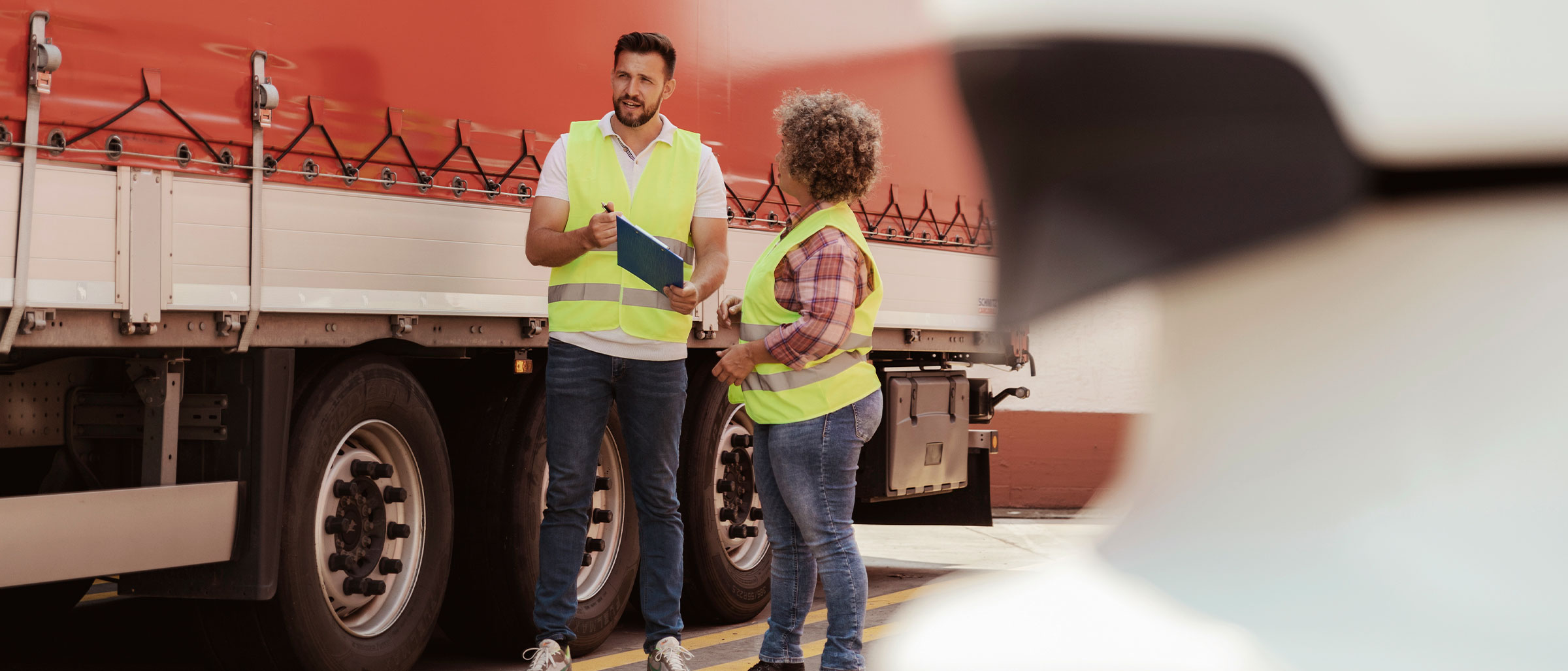 Man and woman standing on the side of a truck