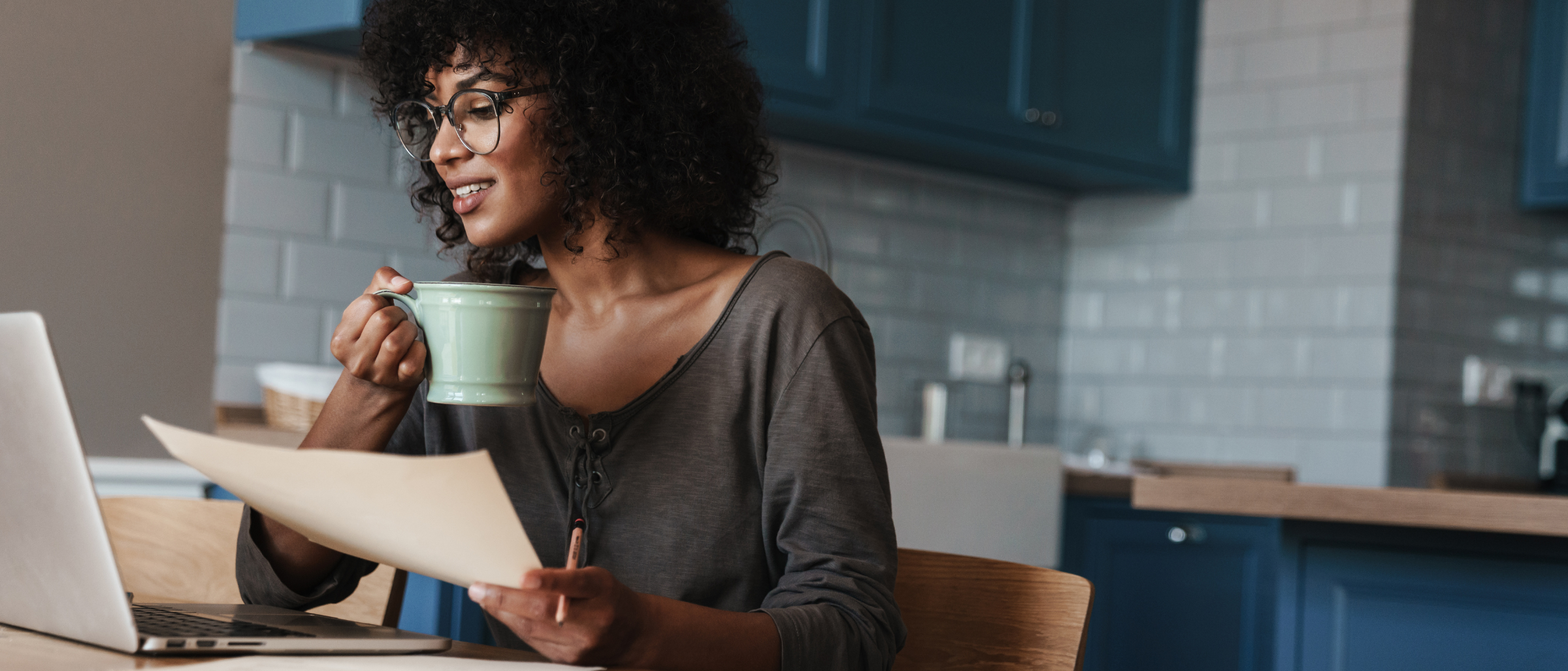 Woman drinking coffee holding paper