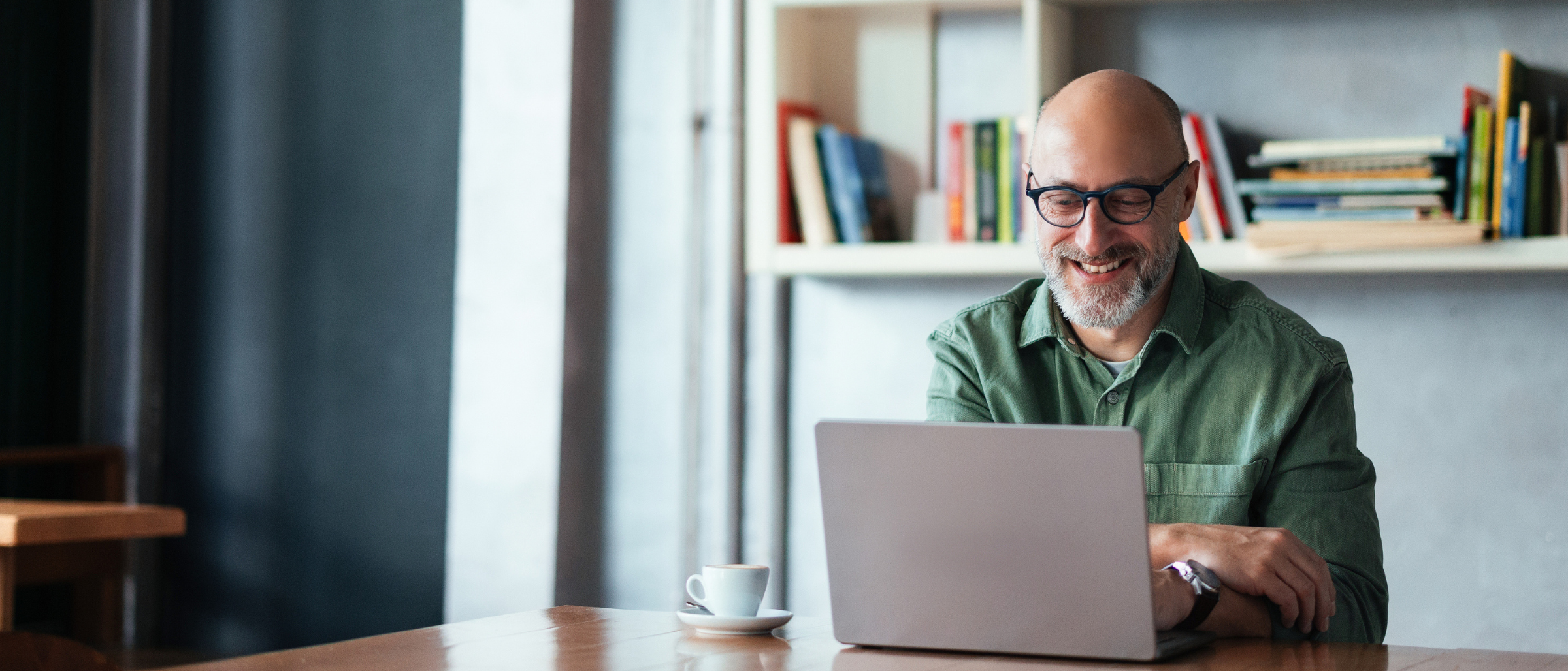Man working at a laptop with a cup of coffee