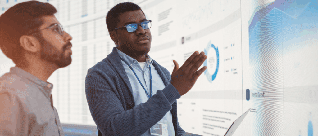 Two men reviewing business analytics on a screen