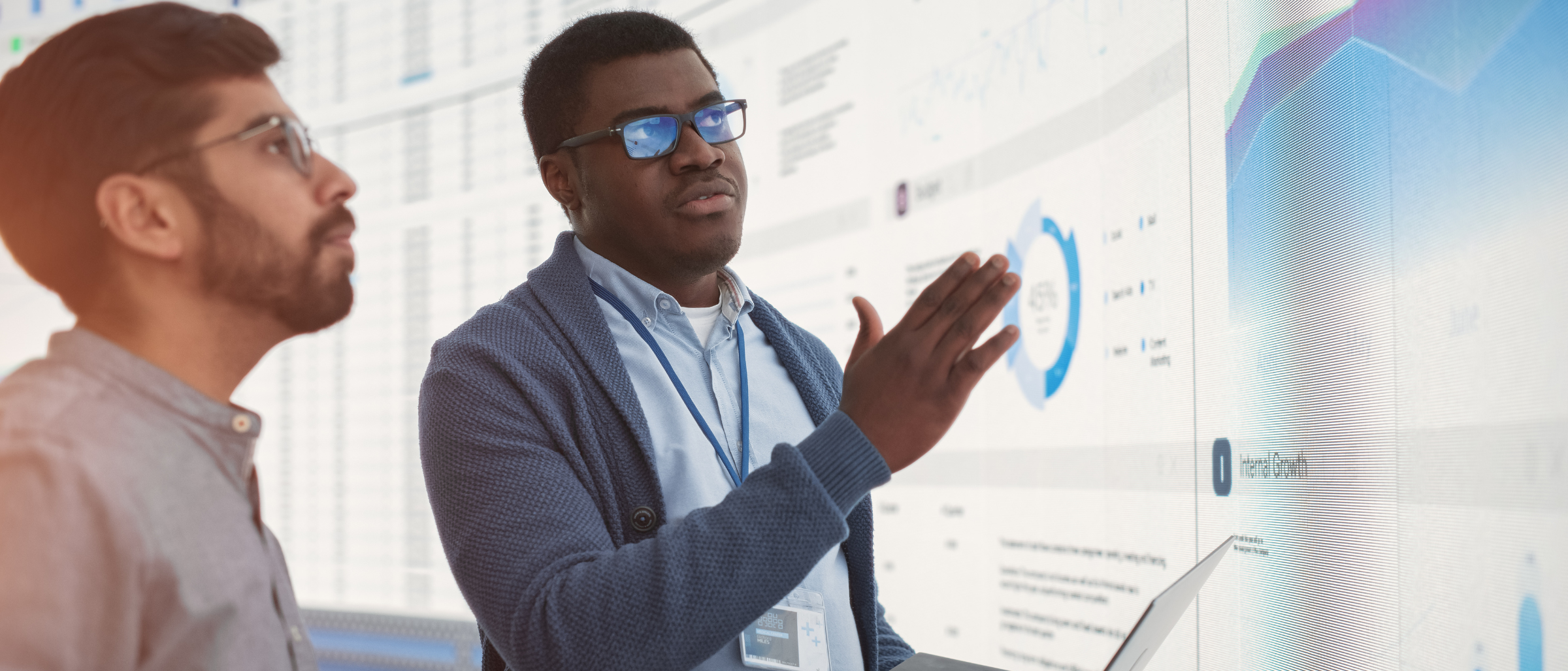Two men reviewing business analytics on a screen