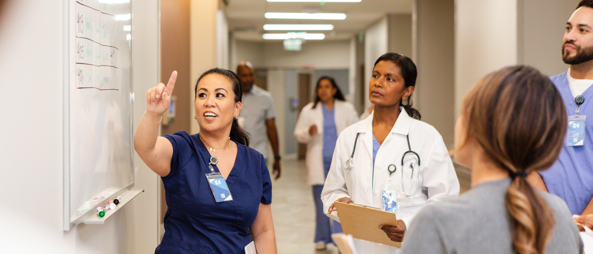 A nurse speaking to a group of medical professionals
