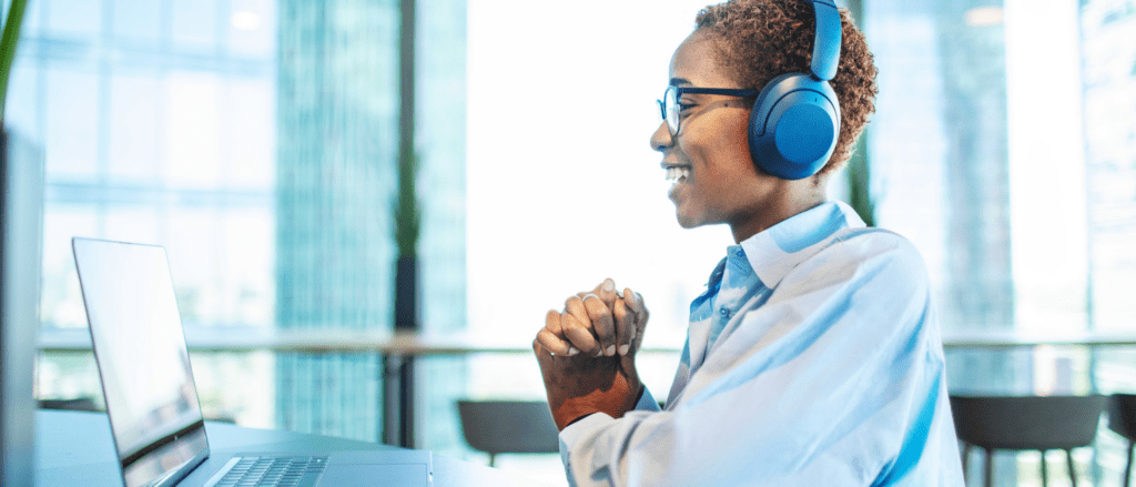 woman sitting at laptop with headphones on