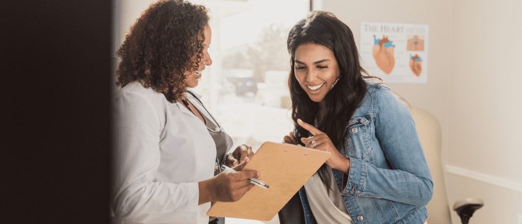woman speaking with a nurse practitioner in a medical exam room