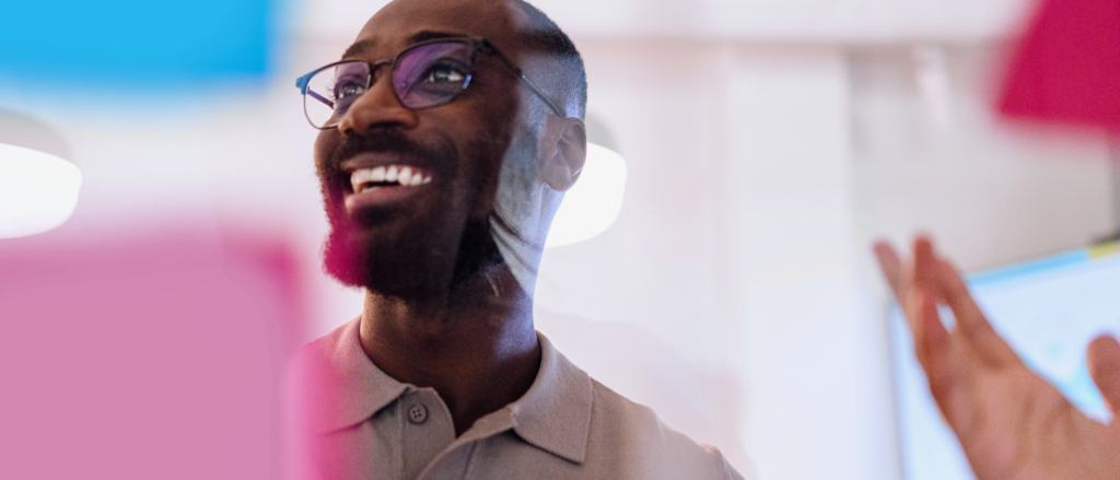 Man smiling behind a window