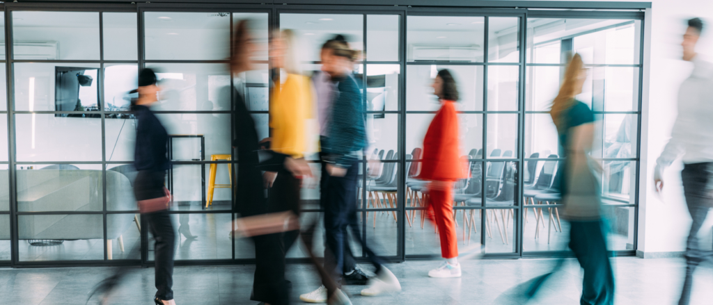 Blurred workers moving through a professional space hallway