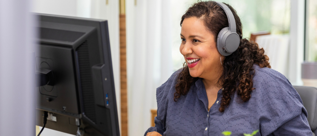 Woman wearing headphones sitting at a computer