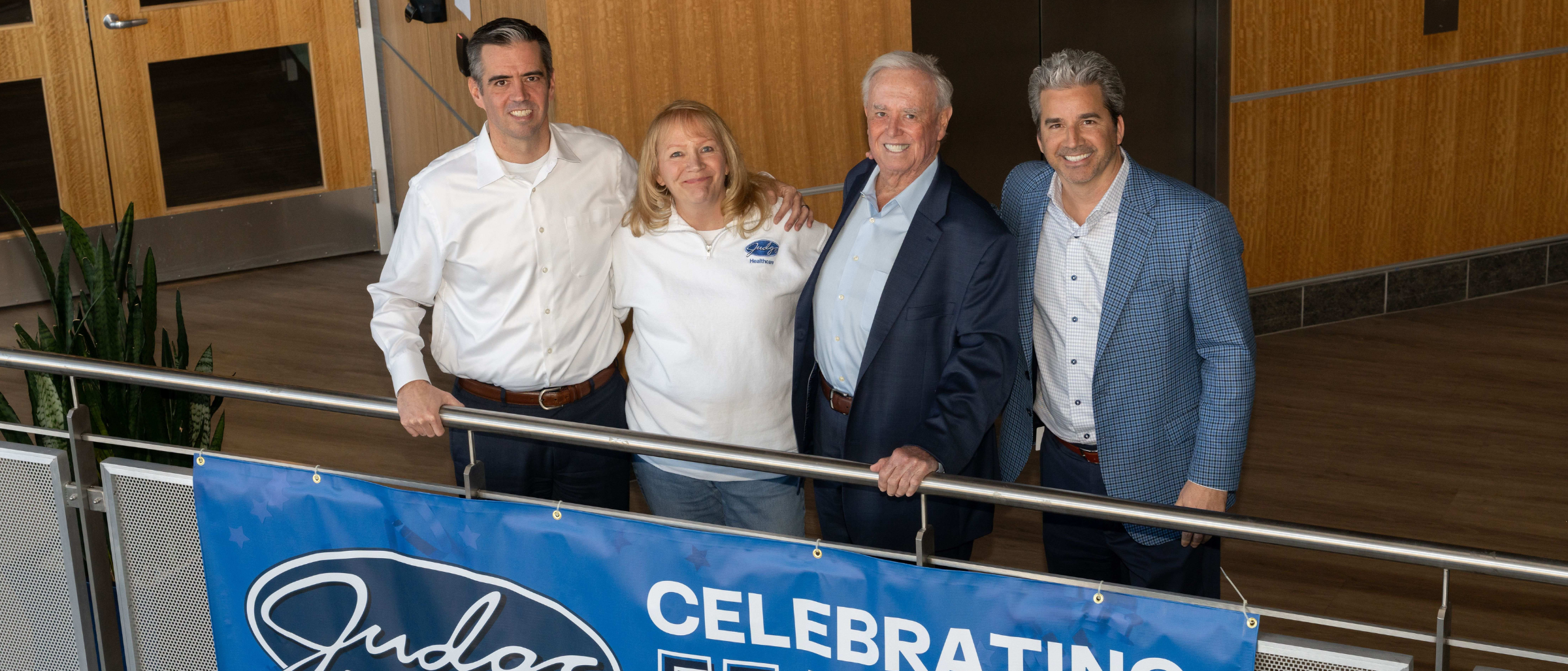 Photo of Martin Judge III, CEO; Katy Wiercinski, COO; Brian Anderson, President; and Martin E Judge, Jr., Founder & Chairman of The Judge Group posing in Judge's corporate office