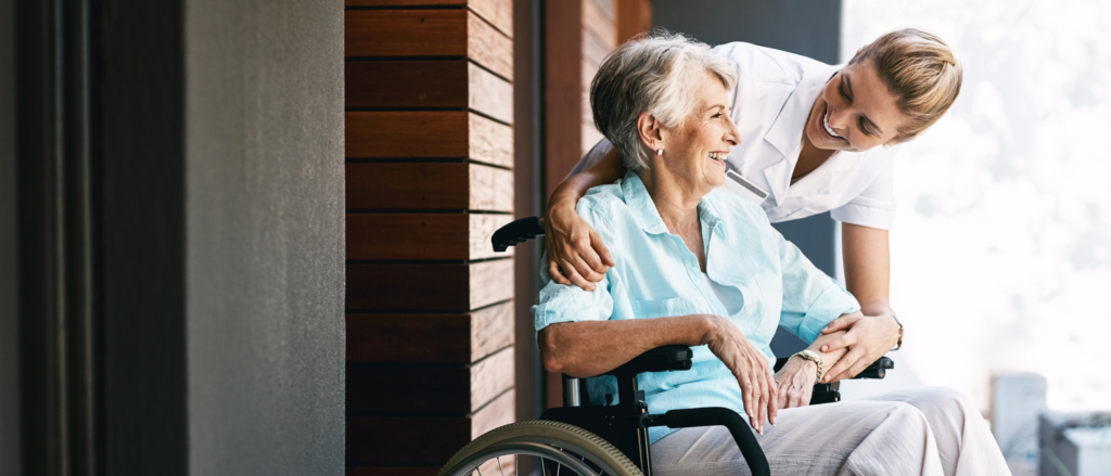 Elderly patient in a wheelchair with their caregiver