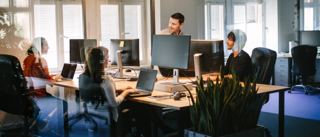 Group of young professionals working at computer stations in an open concept office space