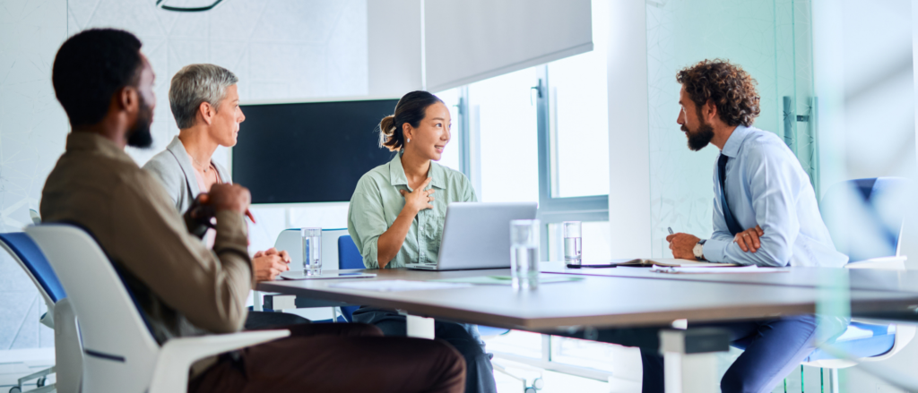 Diverse group of professionals talking around a conference table in an office setting