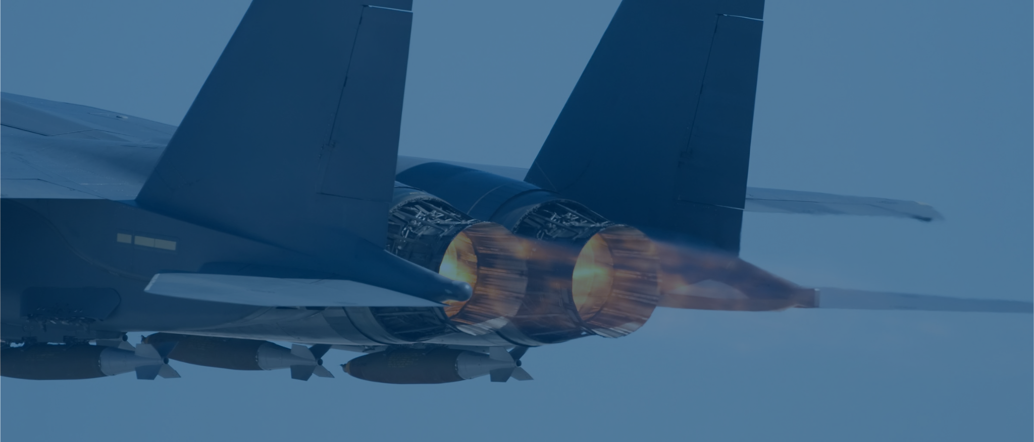 A fighter jet flying off view with engines shooting fire